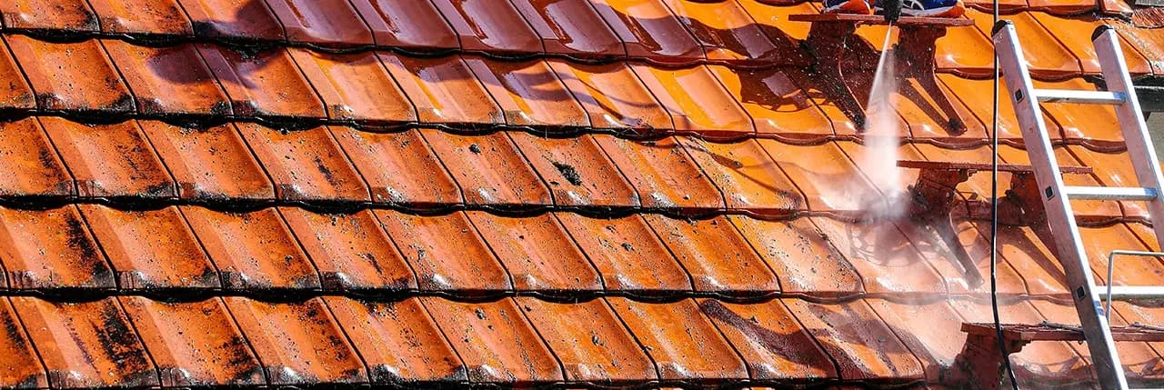Mycie dachu strumieniem wody pod ciśnieniem, obok drabina dachowa